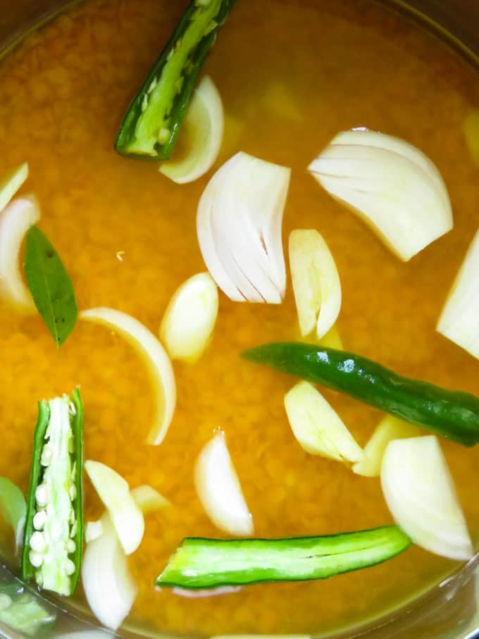 cooking the dhal curry with water onions, garlic.
