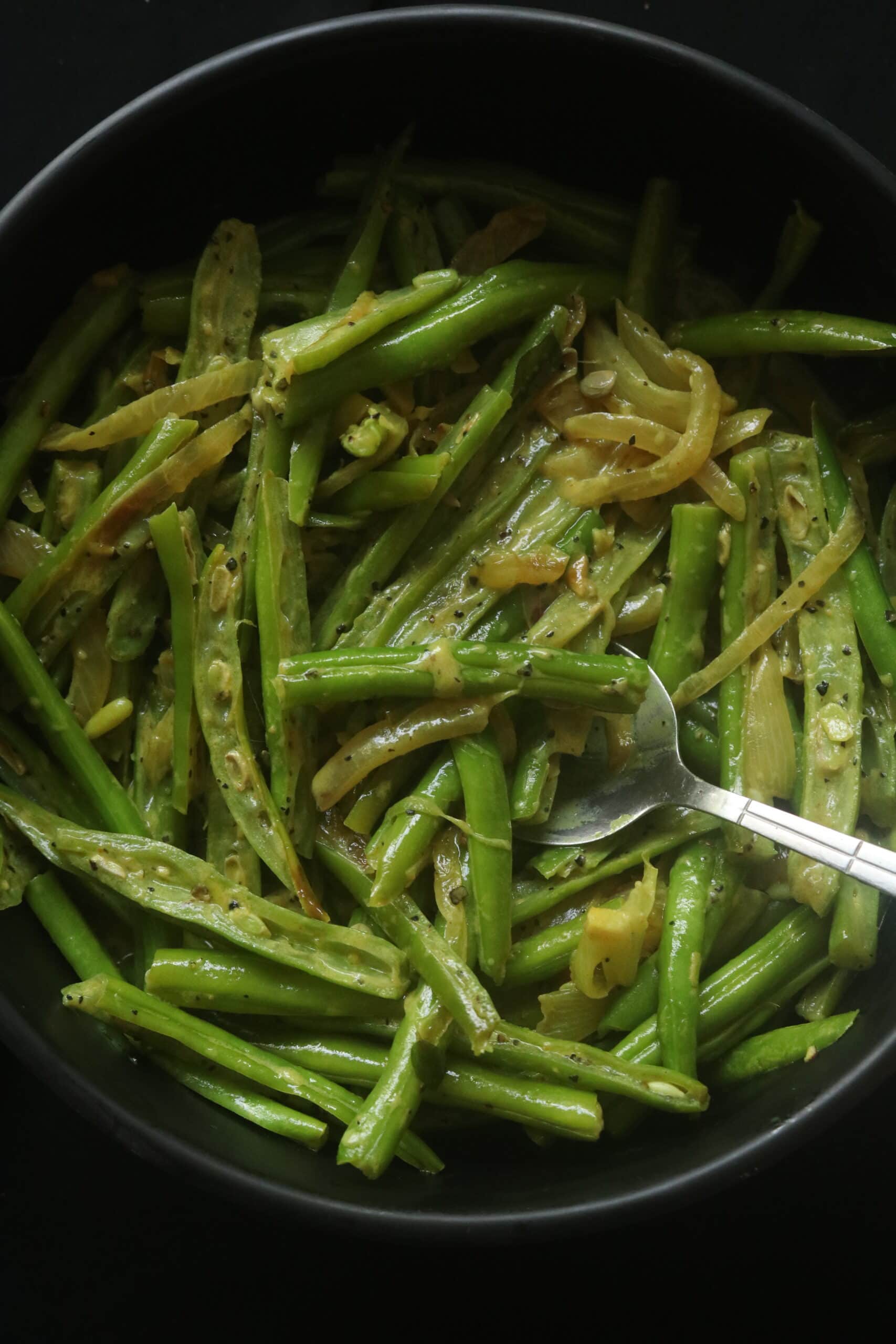 beans curry with coconut milk with a spoon scooping it.