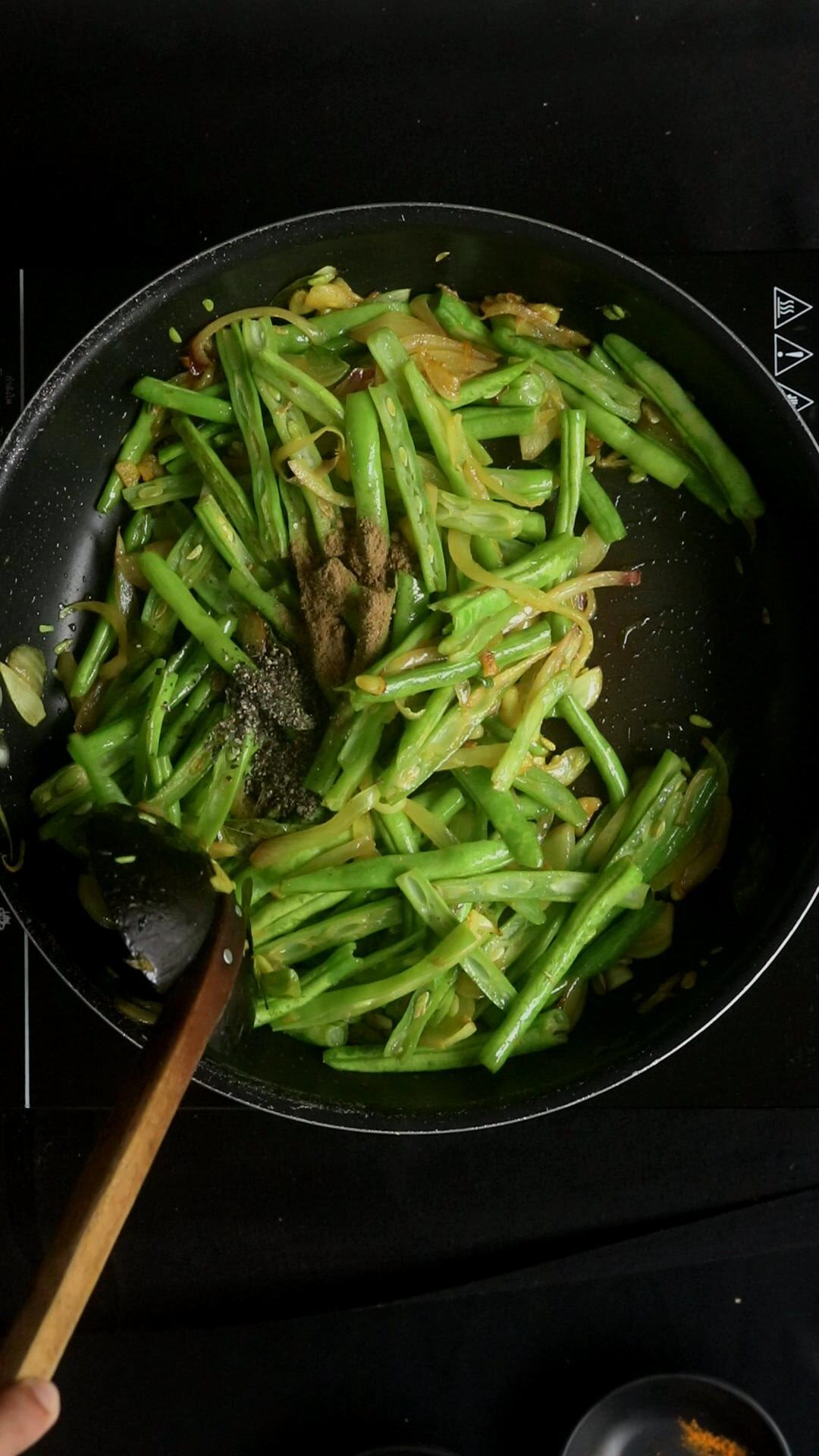 adding the cumin powder and pepper to the beans curry.