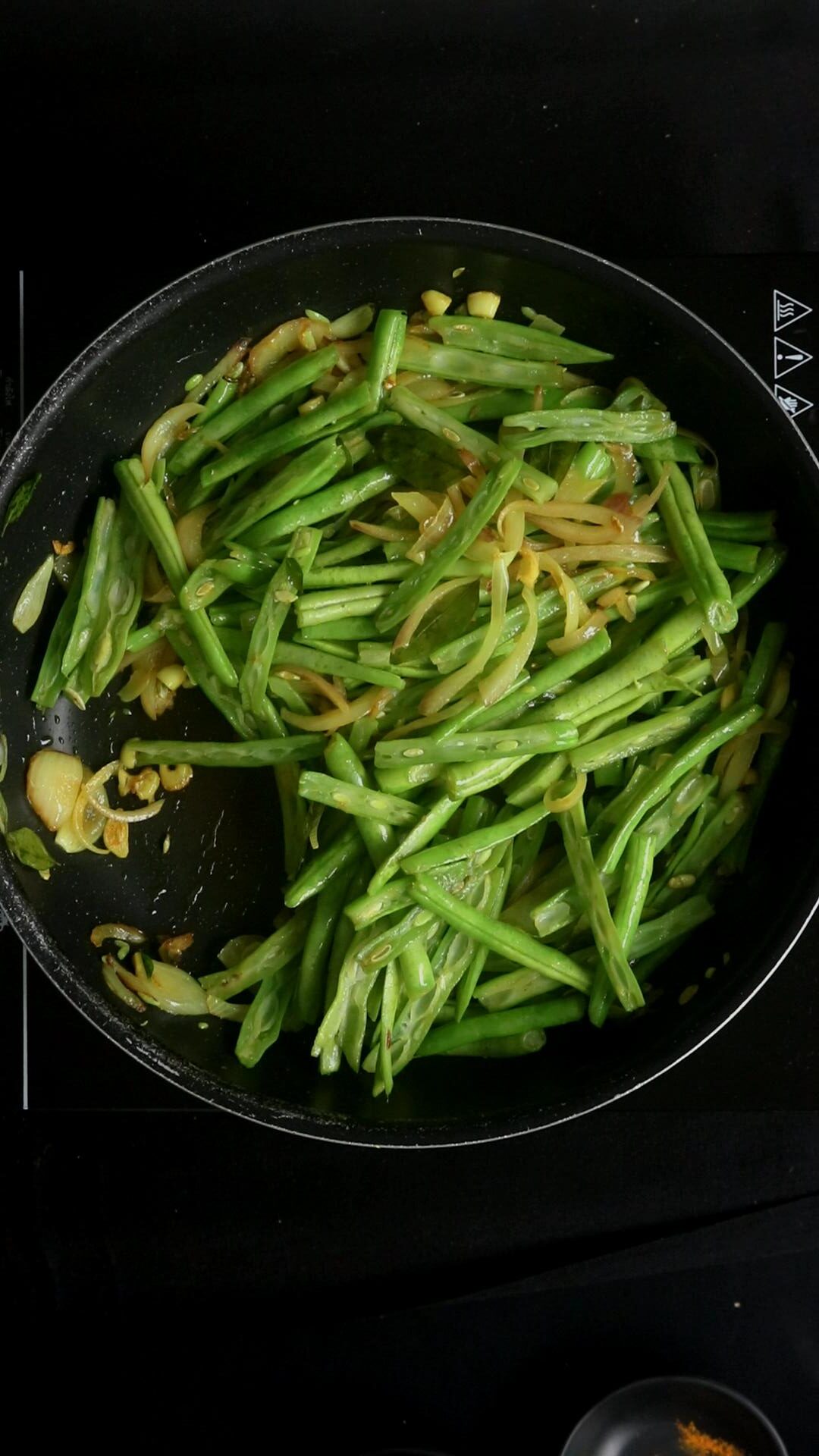 cooking the beans in a pan over medium heat and seasoning with salt.