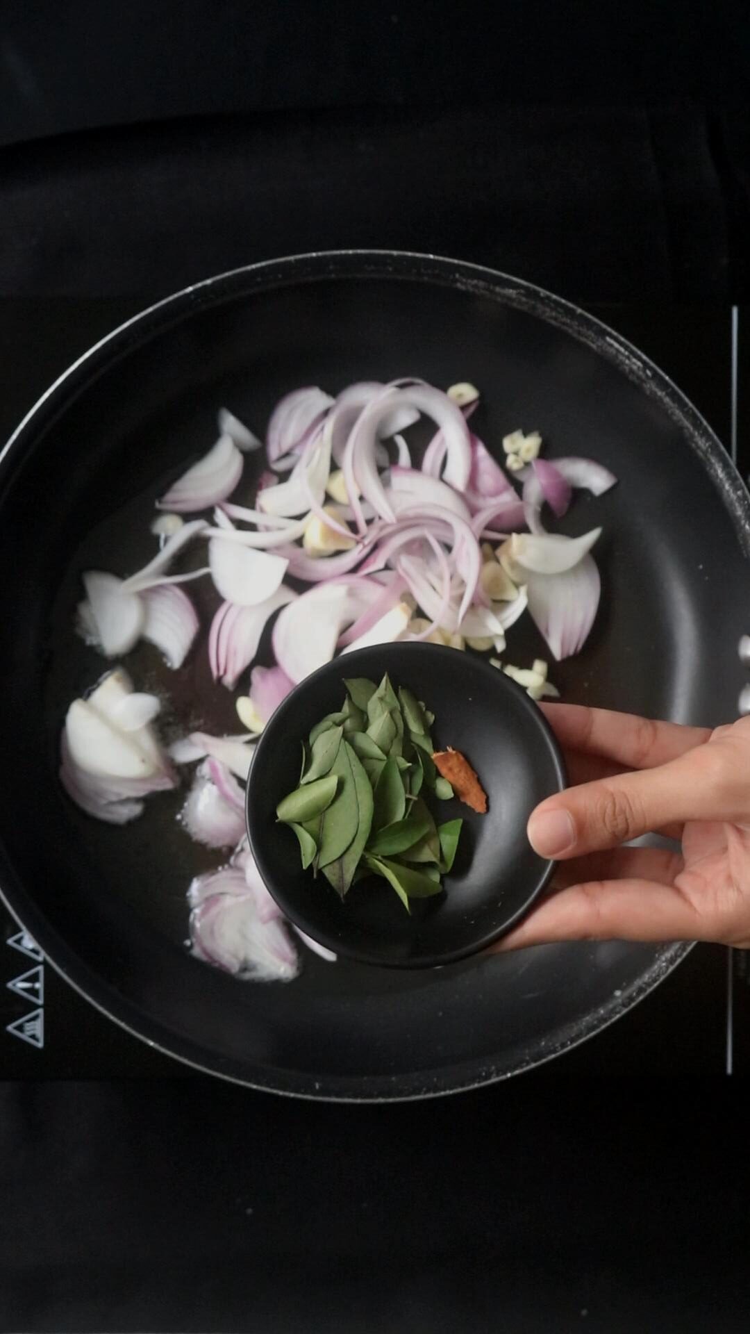 tempering the onions, curry leaves, cinnamon to the pan for the beans curry.