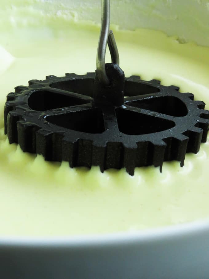dipping the black rosette mould into the batter to make kokis.