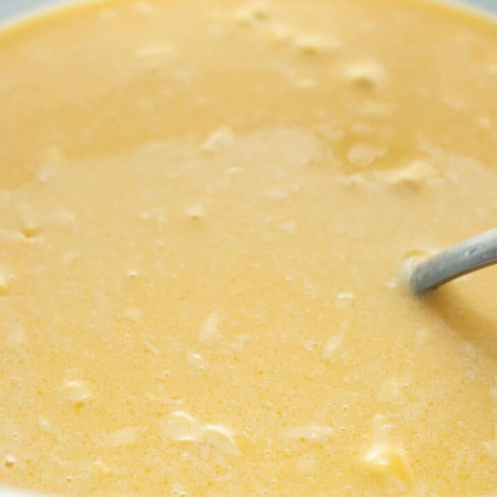 mixing milk. eggs and other wet ingredients to make american pancakes.