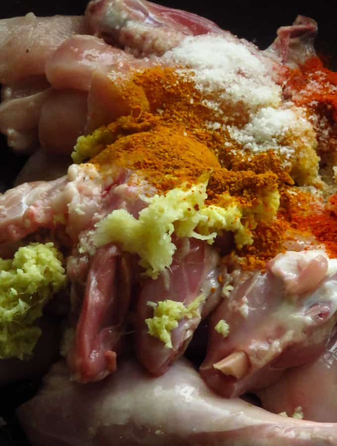 adding ingredients to the chicken parts to marinate.