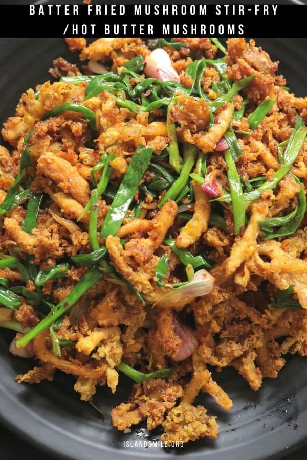 crispy fried mushroom mixed with scallions and placed on a black platter.