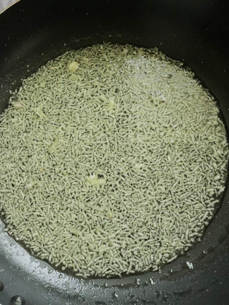 frying the minced garlic in oil in a large pan.