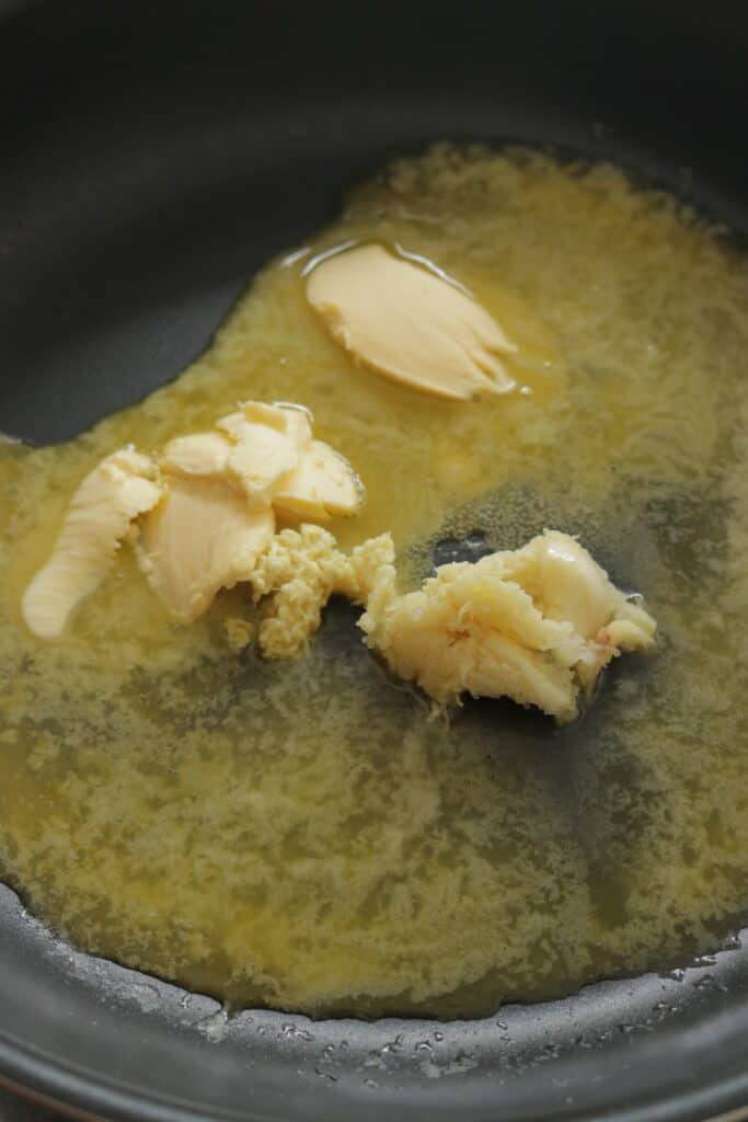 melting butter with minced ginger to make the hot butter mushroom recipe.