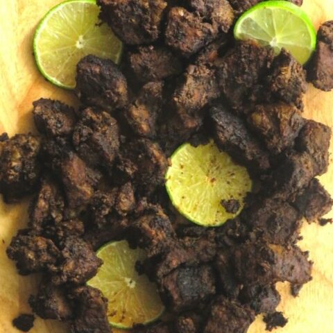 Sri Lankan beef fry with lime wedges.