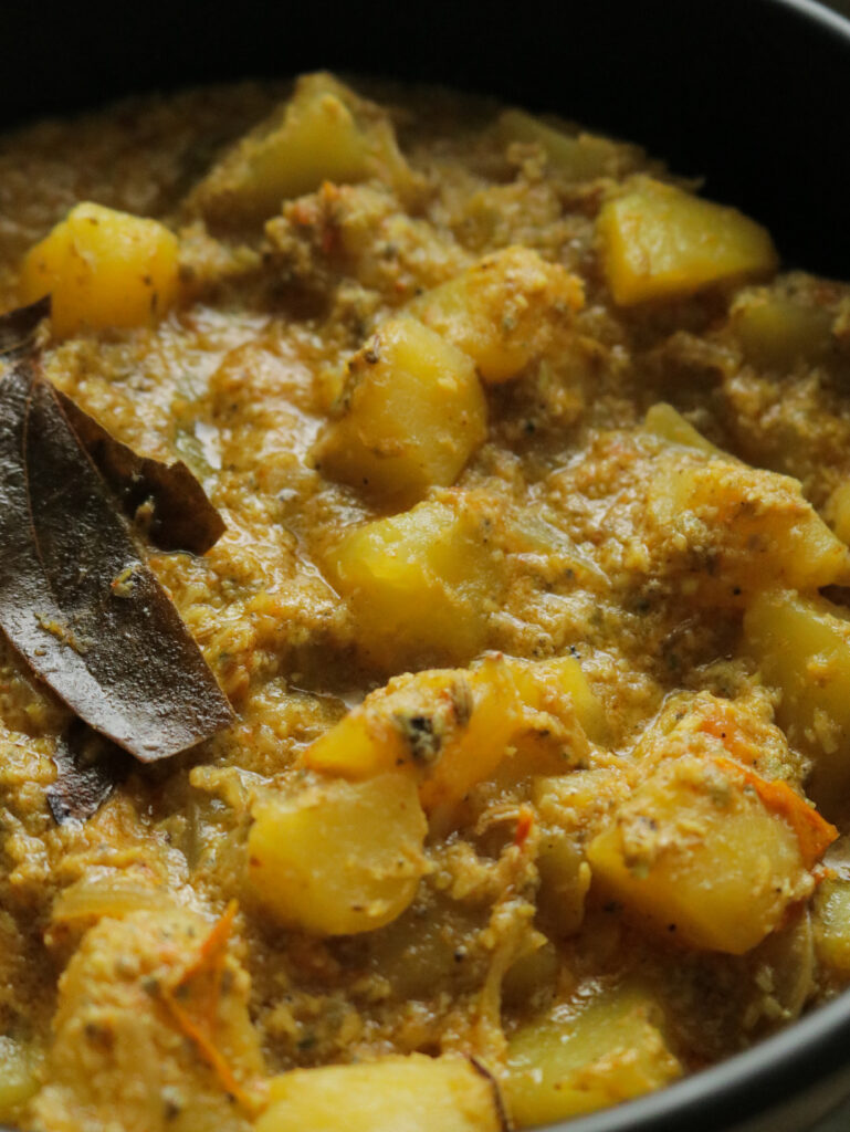 cooked aloo korma serves in a black bowl.
