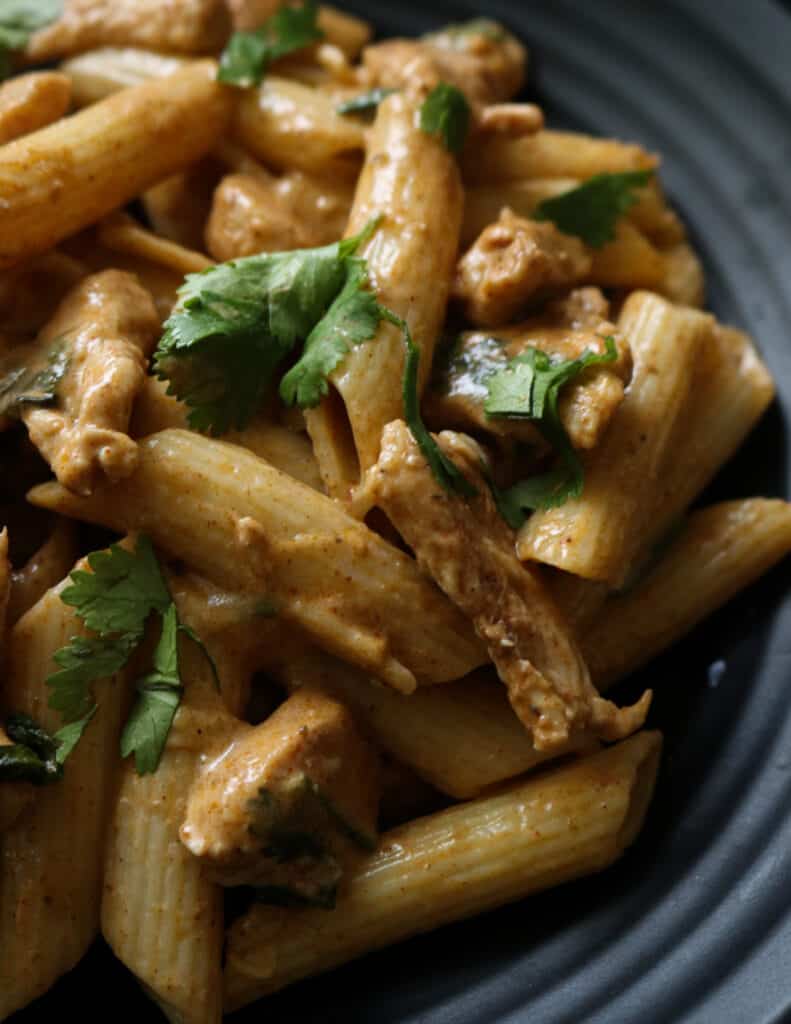 creamy thai chicken curry pasta served on a plate.