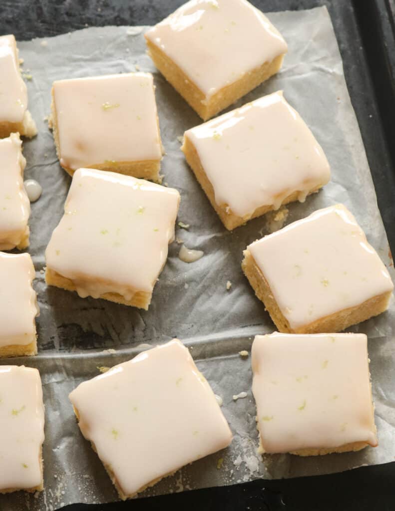 lemon brownie bars with icing drizzled over it.
