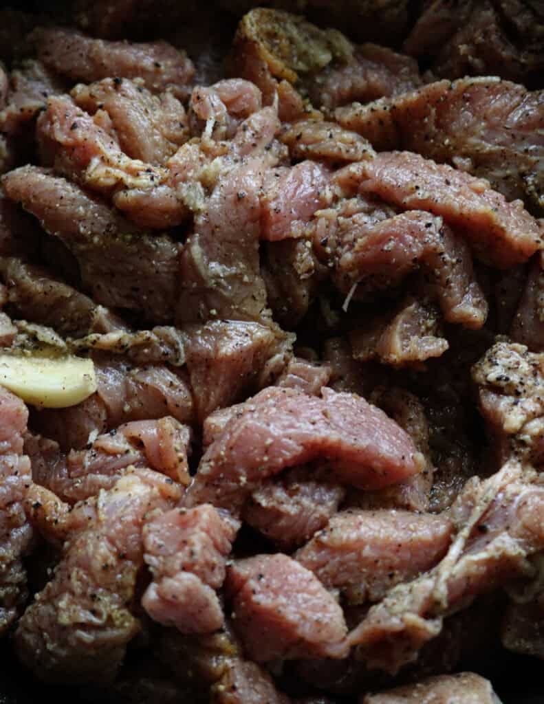 mixing the beef slices with spices and tenderiser. 