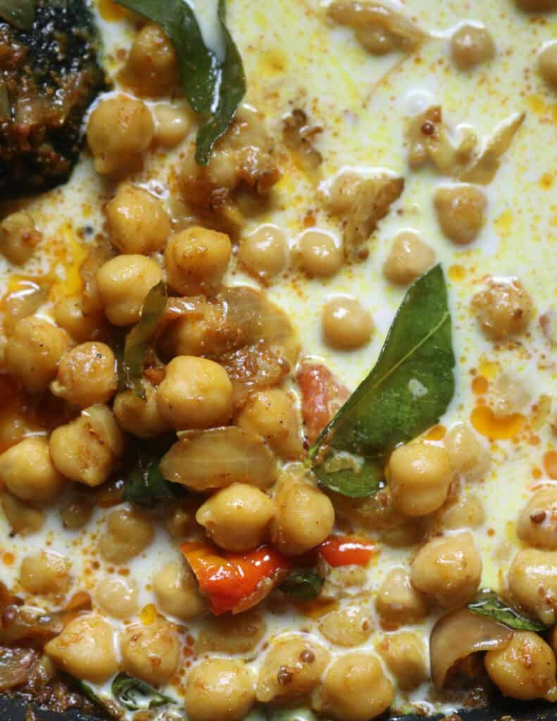 adding coconut milk to the tempered chickpeas.