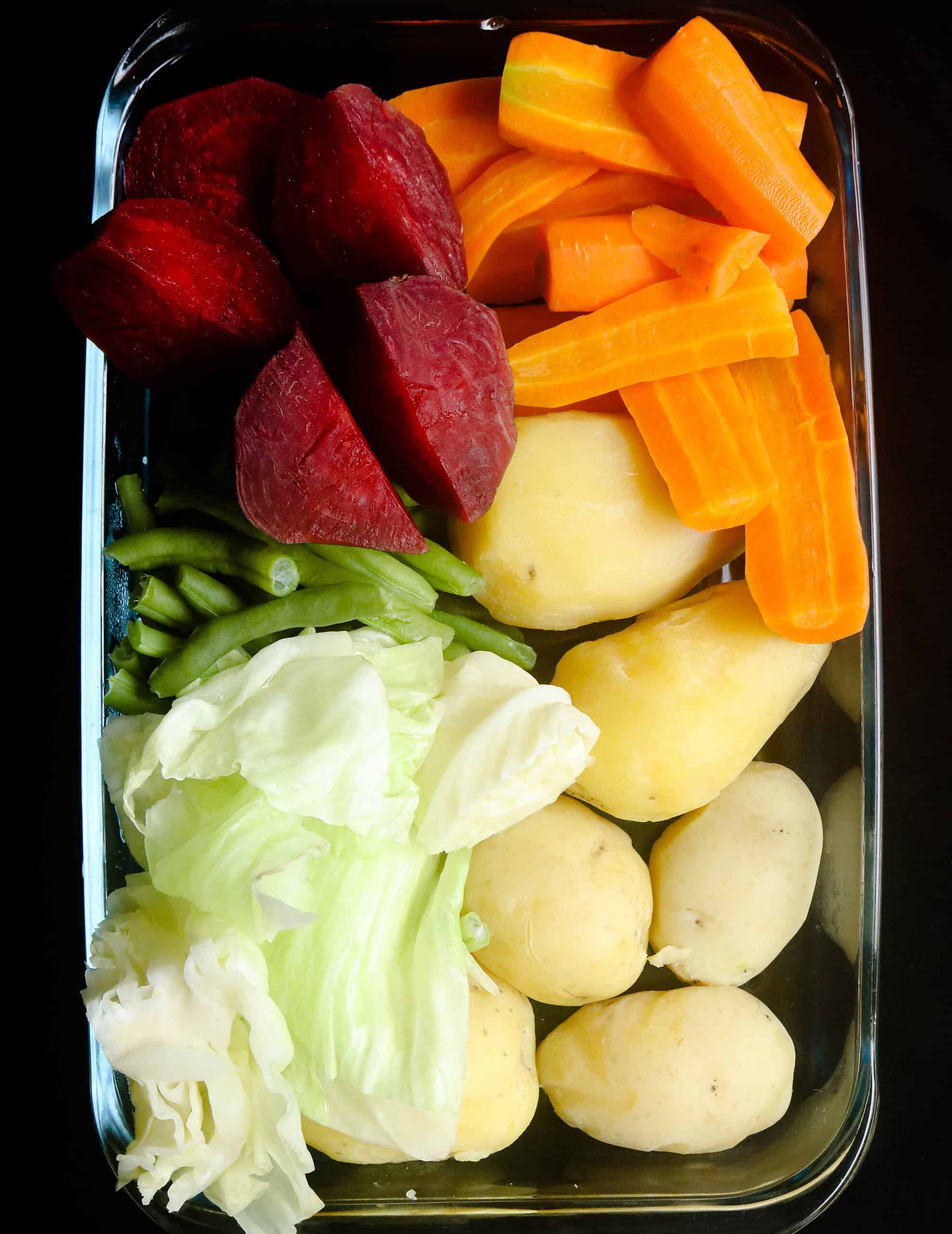 mixed boiled vegetables of beetroot, potatoes, carrots, green beans and cabbages.