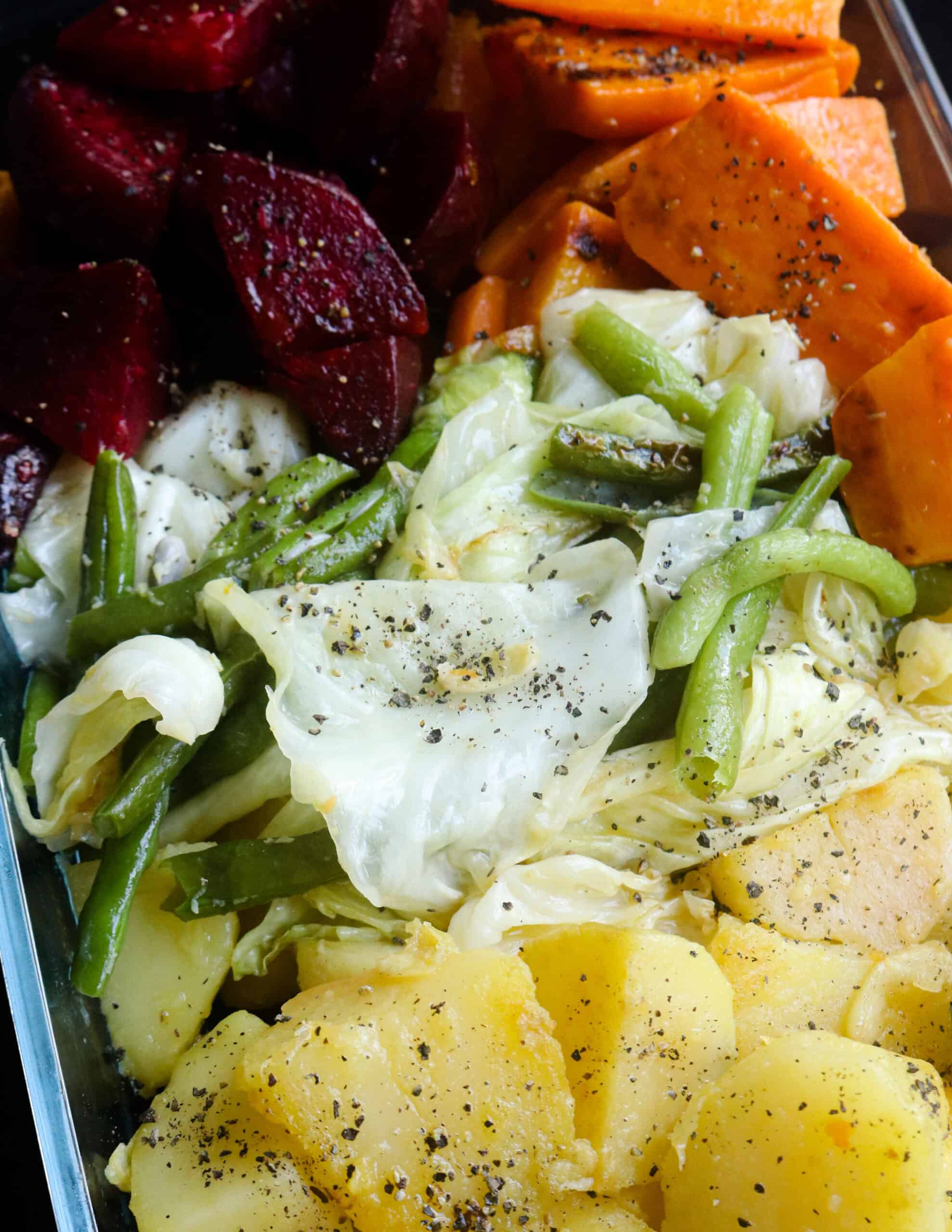 boiled beans, potatoes, carrots, beetroots and cabbage slices served on a pyrex dishes.