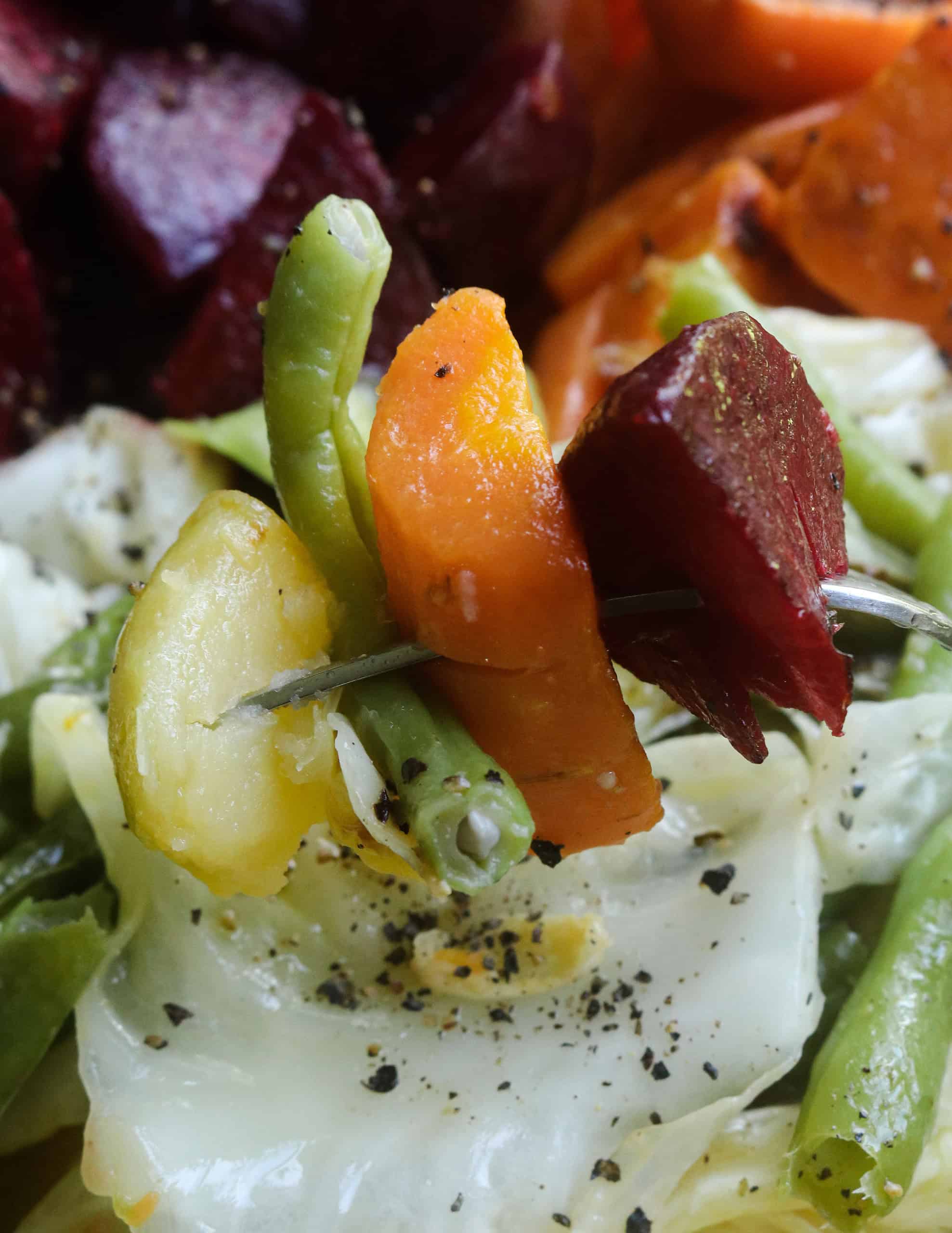 a mix of boiled vegetables in a fork.